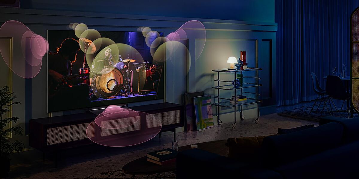A woman sits on a couch watching a concert with bubbles depicting surround sound around her.
