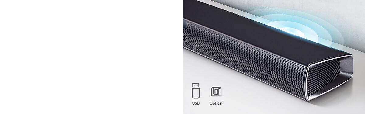 LG Sound Bar is on the white shelf. The Sound graphic coming out from the speaker. It shows USB, Optical icons.