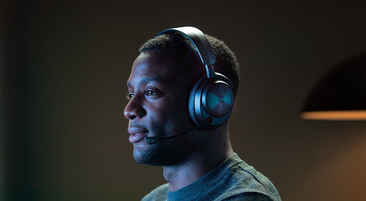 A person wears an Arctis Nova Wireless headset while playing a game.