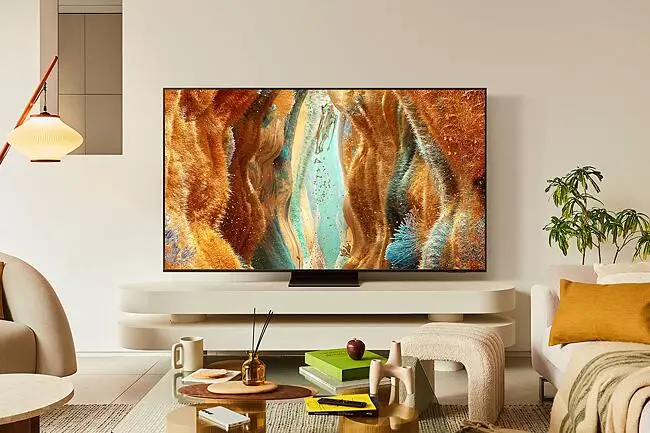 Dağınık Bir Oturma Odasında, Samsung Neo QLED TV Ekranında çimenlik Ve Fantastik Bir Manzara Gösteriliyor. 10